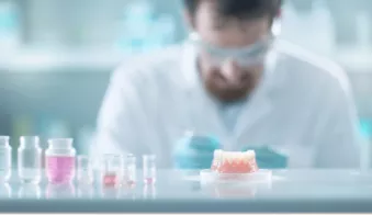 A male scientist in a lab working on an orthodontic typodont